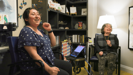 A staff member shares a laugh with a resident near a Connect Four game and art display at our senior living community in Highland Park, IL.